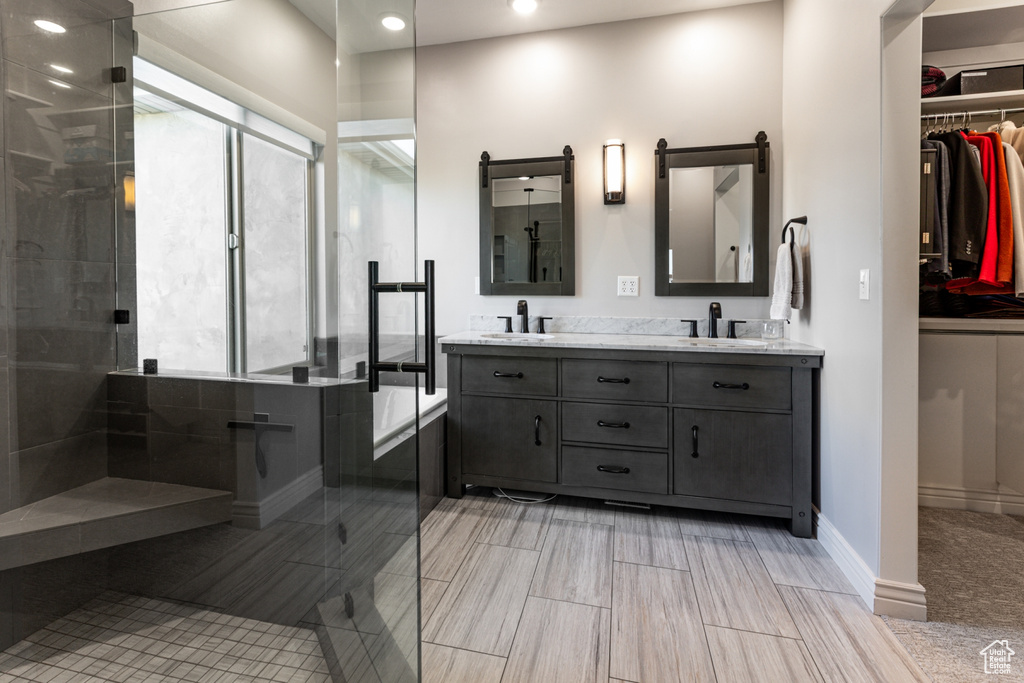Full bathroom with a sink, a tile shower, and recessed lighting