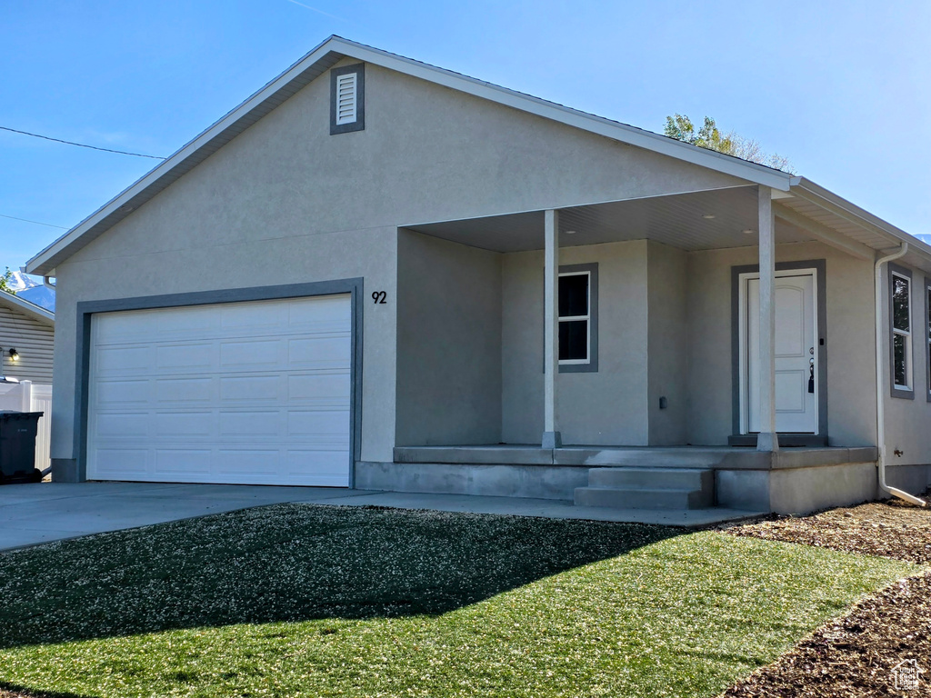 Ranch-style home featuring stucco siding and covered porch