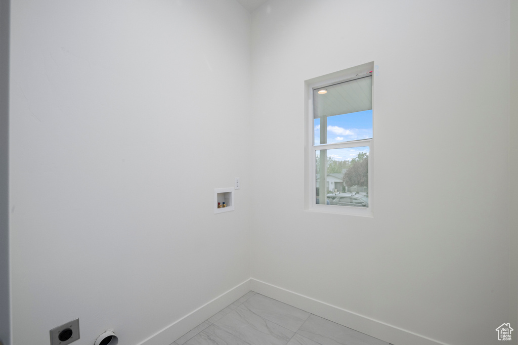Clothes washing area with laundry area, marble finish floor, baseboards, hookup for a washing machine, and electric dryer hookup