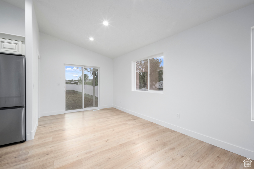 Unfurnished dining area with recessed lighting, baseboards, vaulted ceiling, and light wood-type flooring
