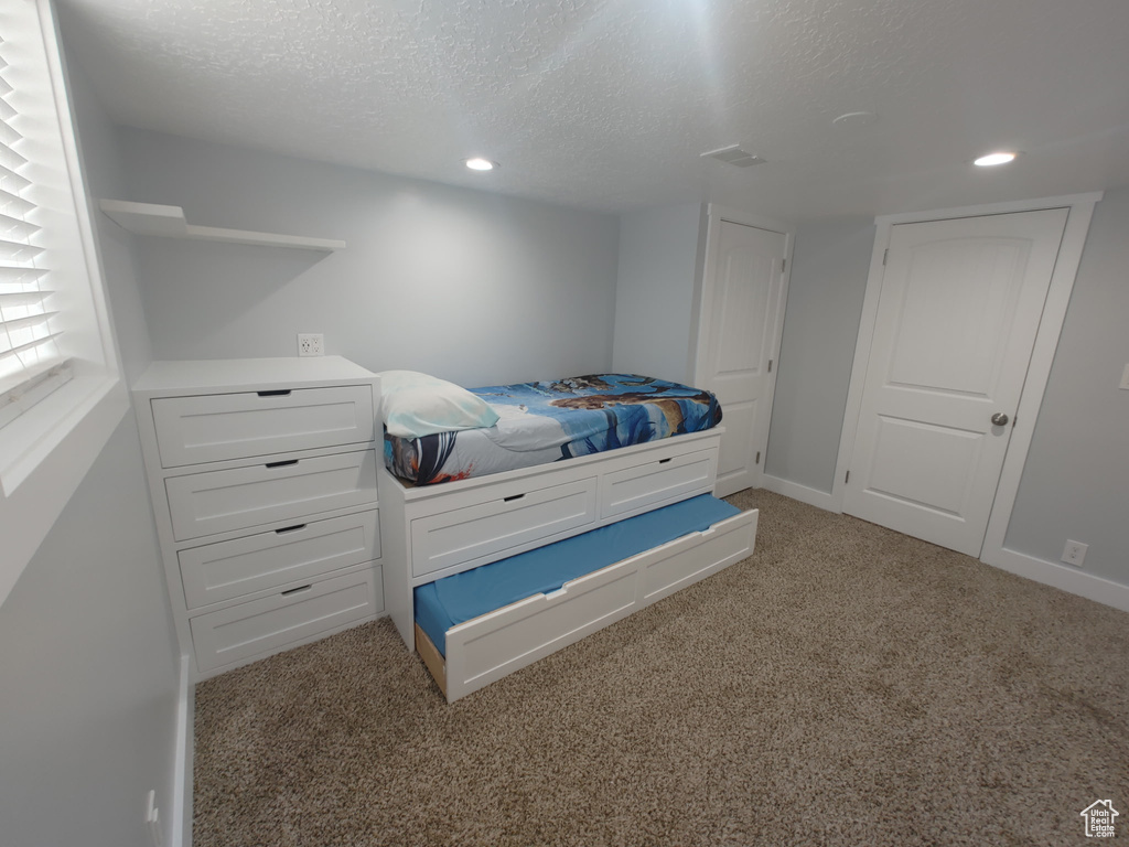 Bedroom featuring light carpet, recessed lighting, and a textured ceiling