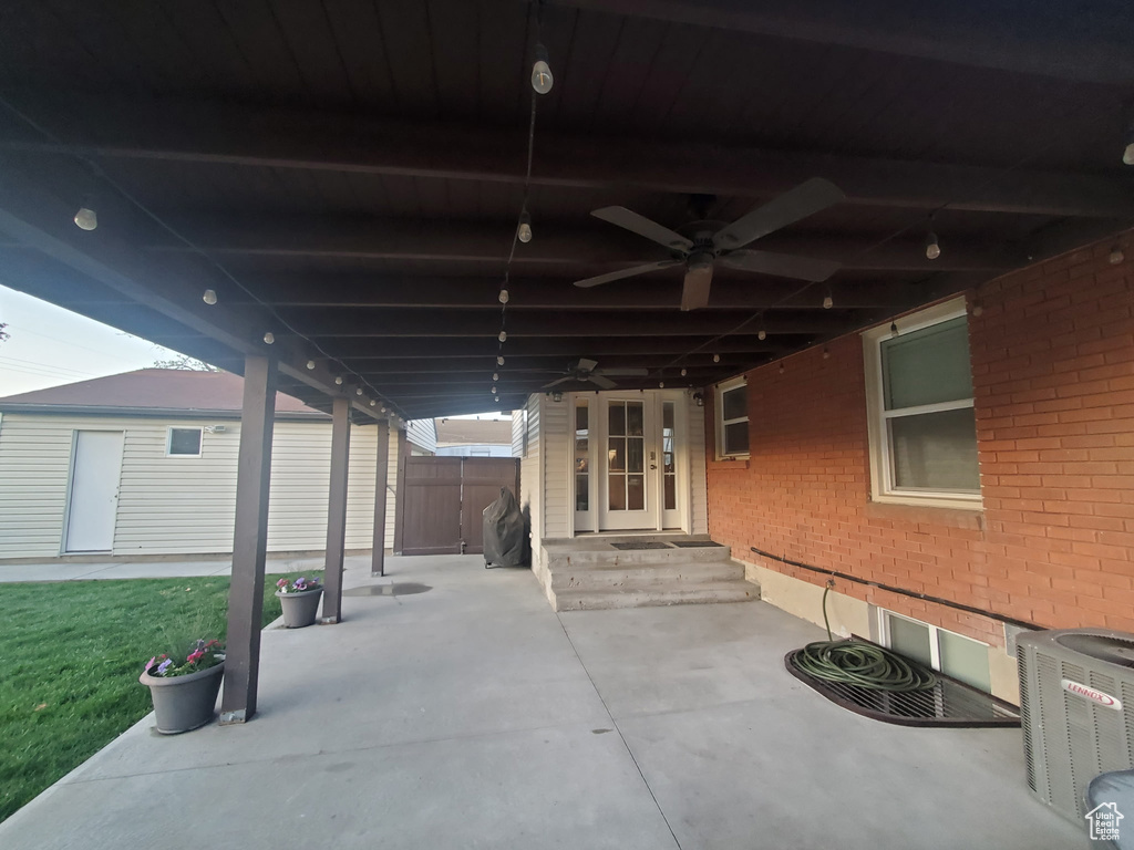 View of patio featuring fence, ceiling fan, and cooling unit