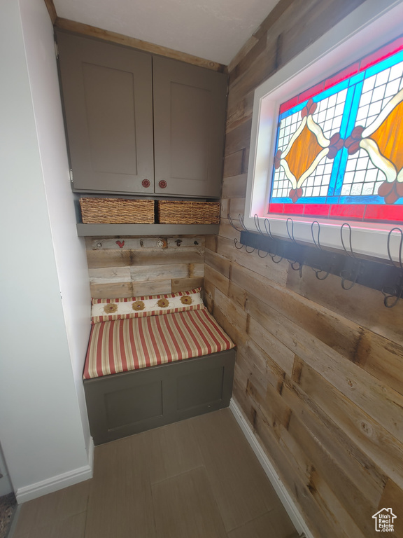 Mudroom featuring wooden walls and baseboards