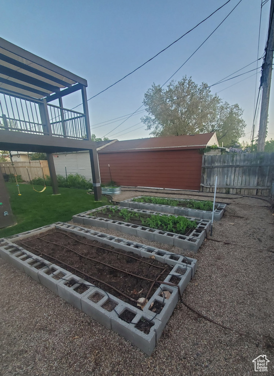 View of yard with fence, a garden, and a playground