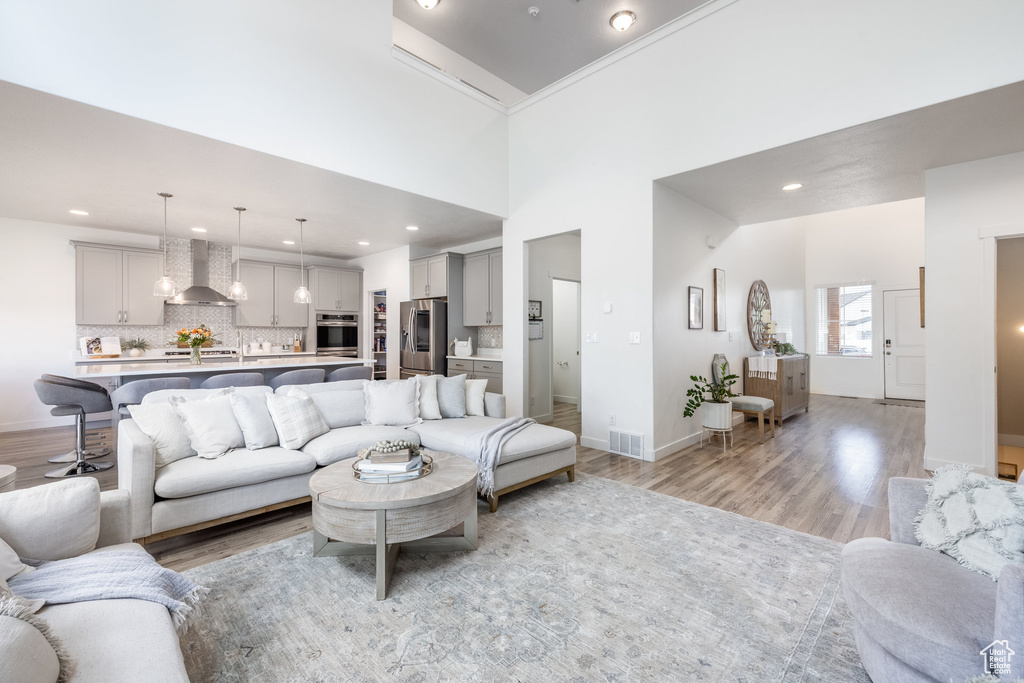 Living area featuring recessed lighting, baseboards, visible vents, and light wood-style floors