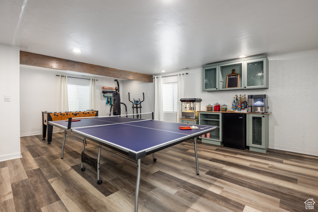 Playroom with baseboards, a dry bar, wood finished floors, and a healthy amount of sunlight