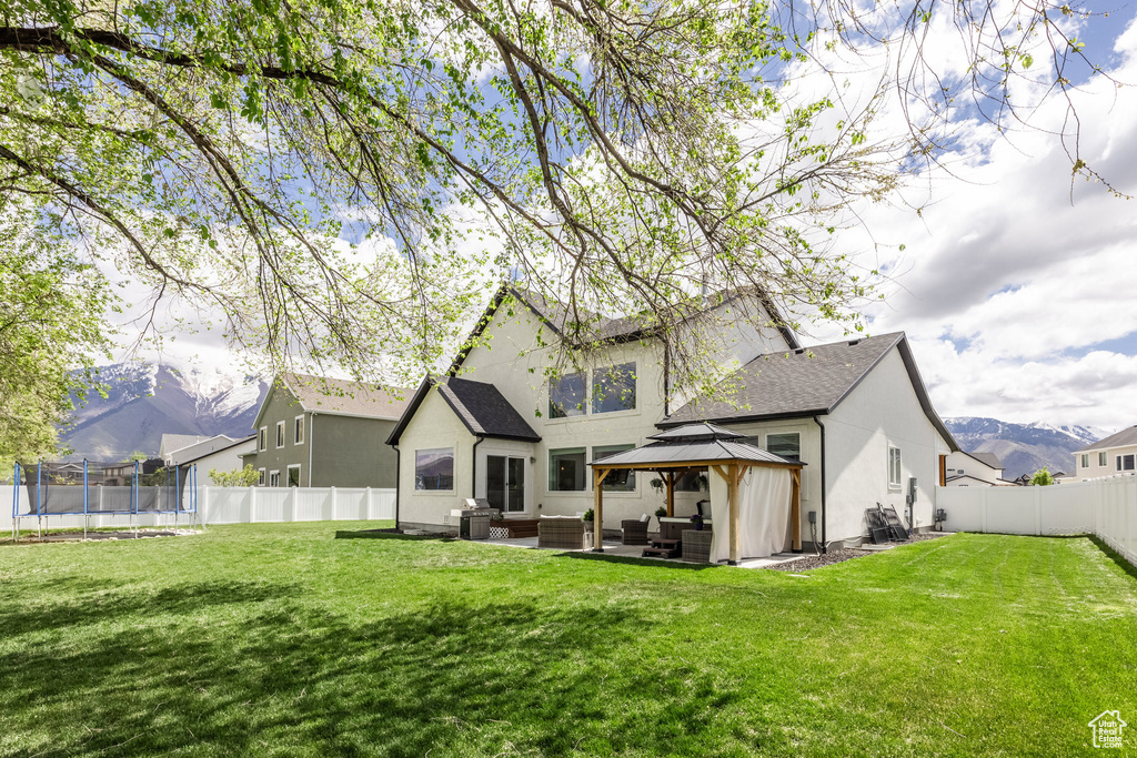 Rear view of house with an outdoor hangout area, a gazebo, a yard, and a fenced backyard