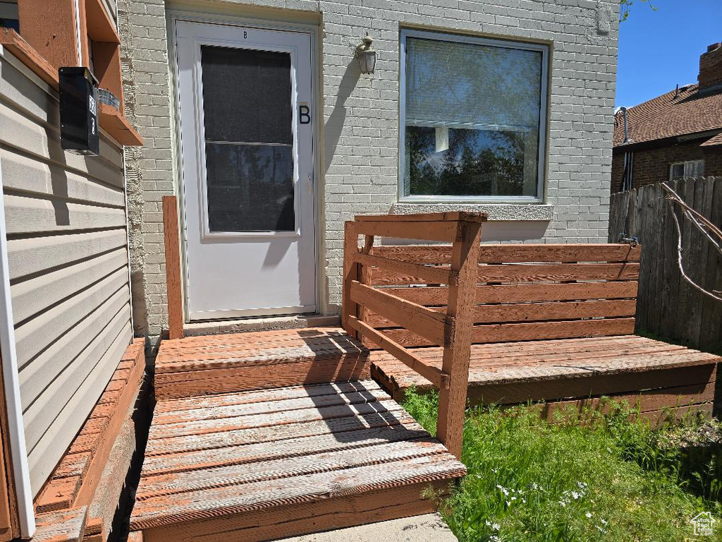 Entrance to property featuring fence and brick siding