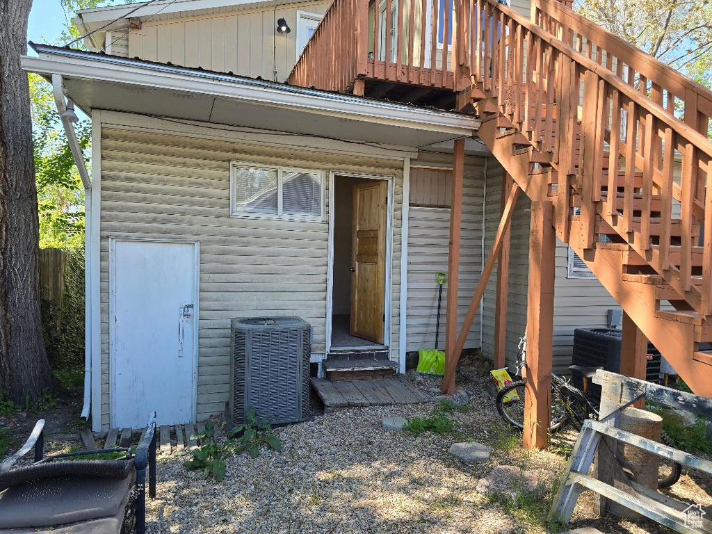 Property entrance featuring board and batten siding and cooling unit