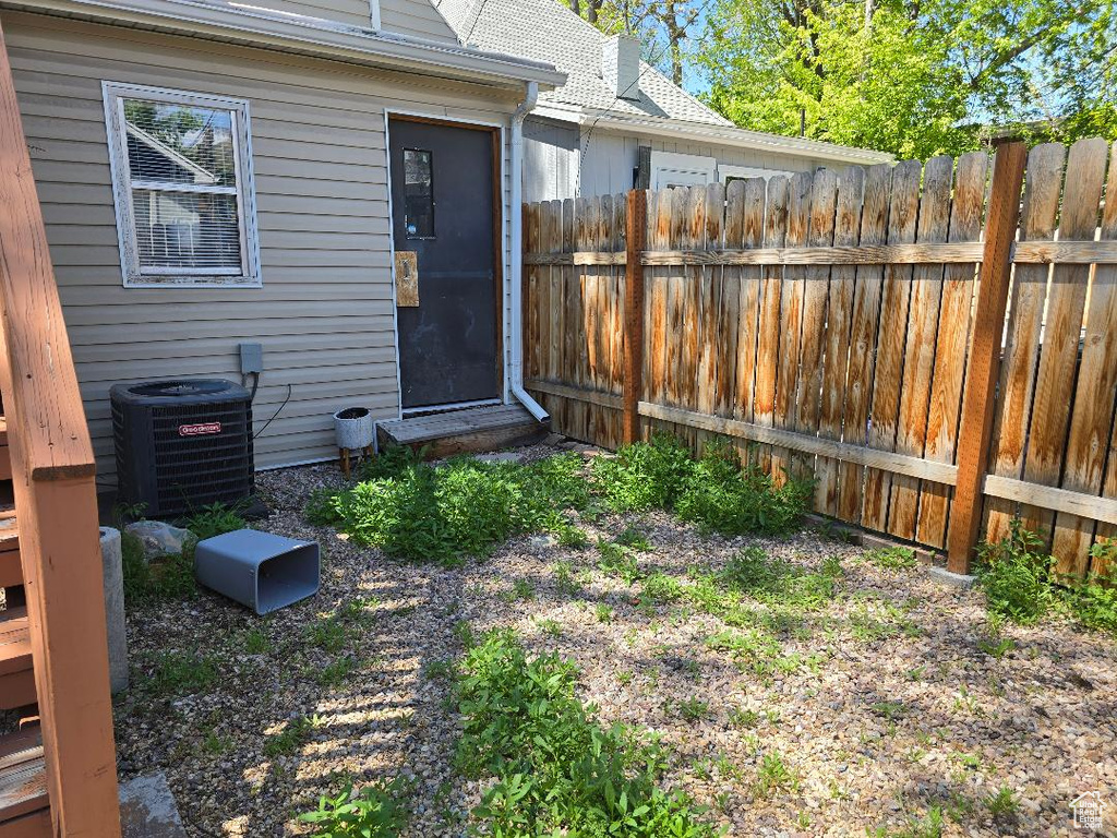 View of yard with central air condition unit and fence