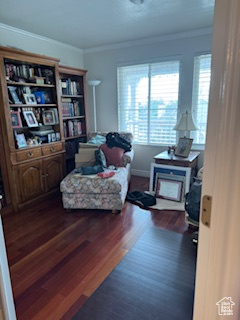 Living area featuring crown molding, baseboards, and wood finished floors