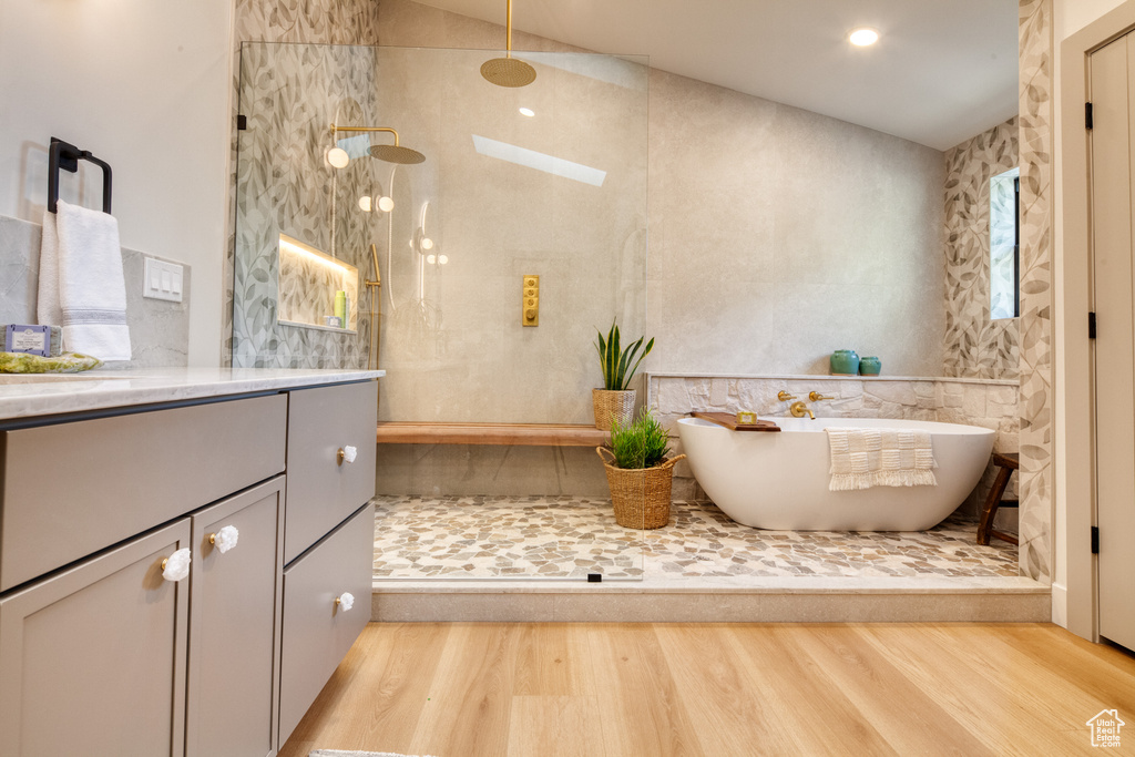 Full bath with a walk in shower, plenty of natural light, and wood finished floors