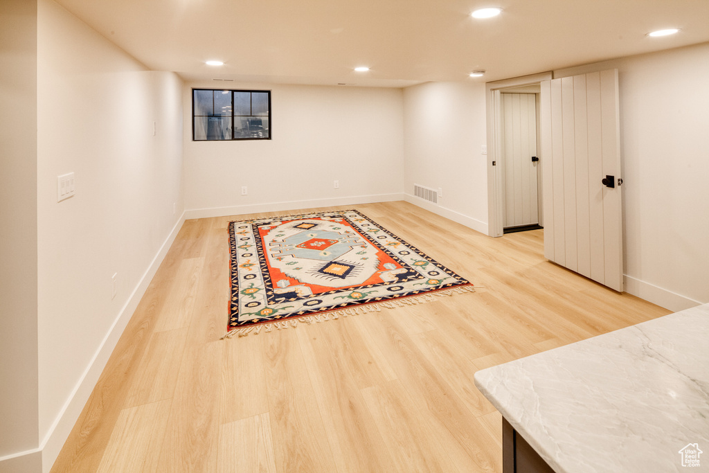Finished below grade area featuring recessed lighting, baseboards, visible vents, and light wood-type flooring