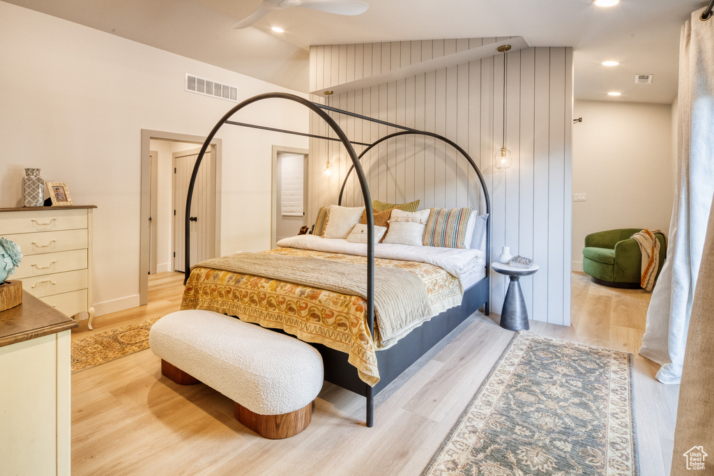 Bedroom featuring visible vents, wood finished floors, and vaulted ceiling