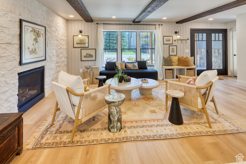 Sitting room featuring french doors, a fireplace, wood finished floors, beamed ceiling, and recessed lighting