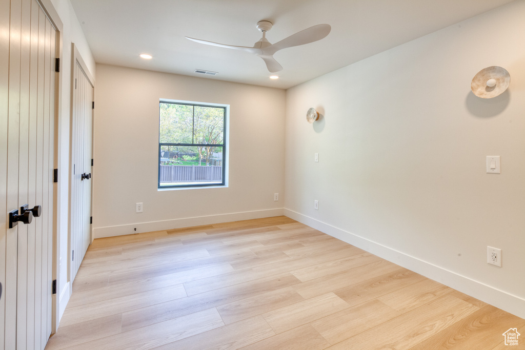 Interior space with visible vents, a ceiling fan, light wood-style flooring, and baseboards