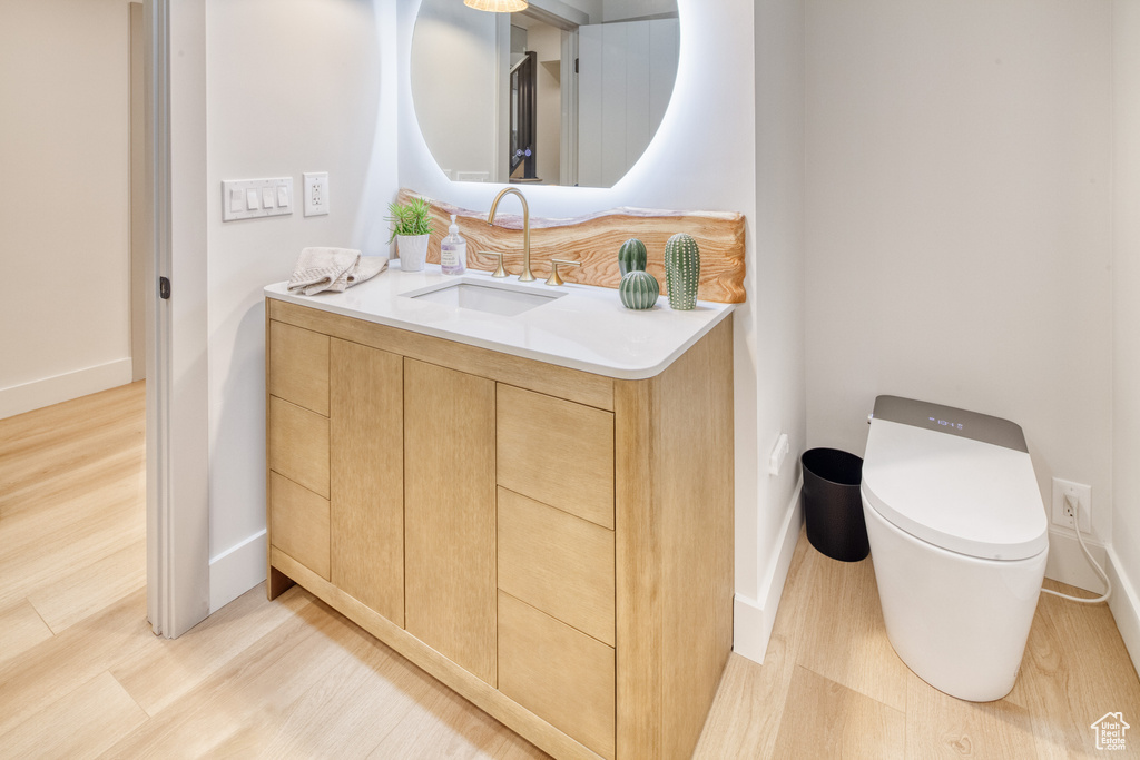 Bathroom with baseboards, toilet, and wood finished floors