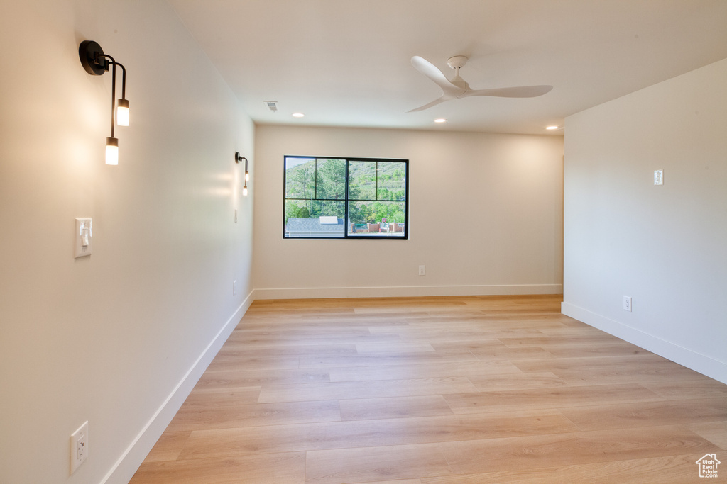 Spare room featuring baseboards, light wood finished floors, a ceiling fan, and recessed lighting