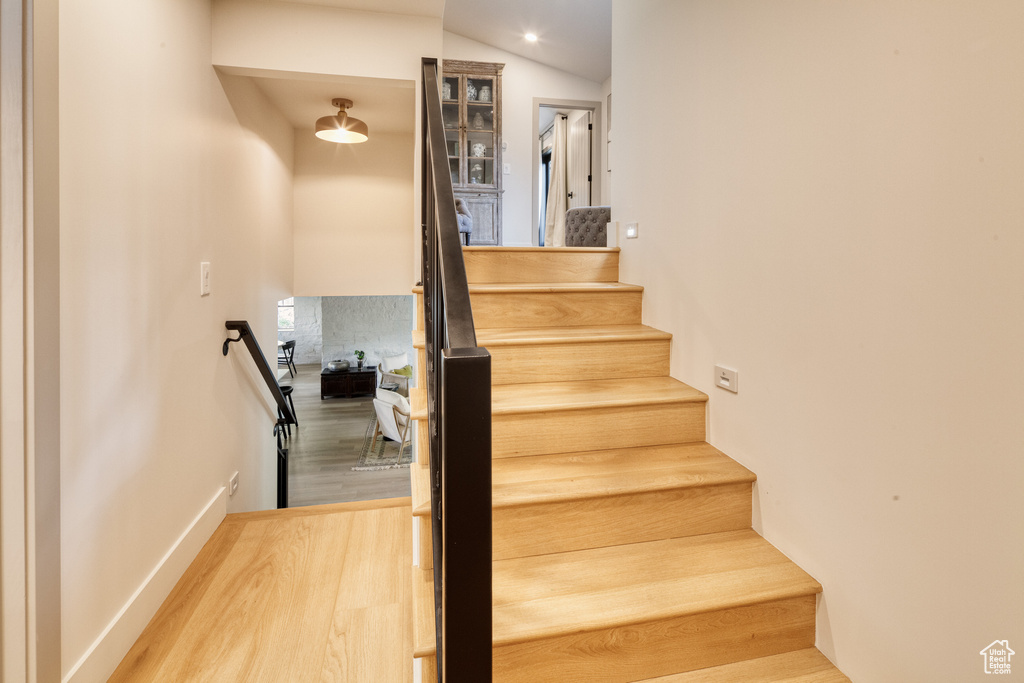 Staircase with recessed lighting and wood finished floors