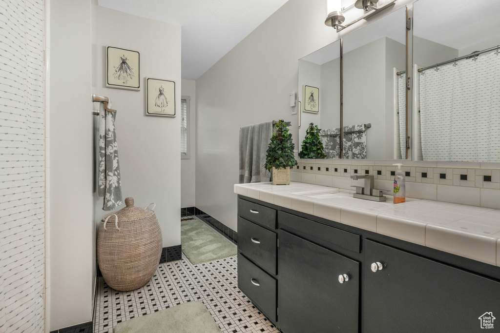 Bathroom with vanity and tasteful backsplash