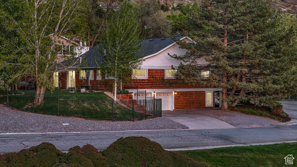 View of front of house with an attached garage, a front lawn, and concrete driveway