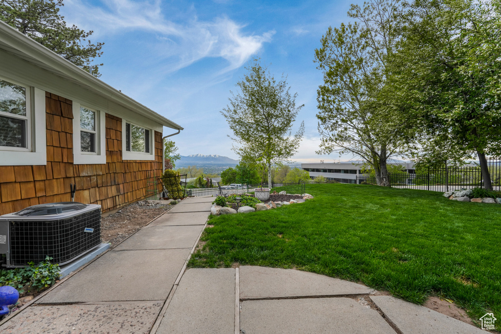View of yard featuring a mountain view, fence, and cooling unit