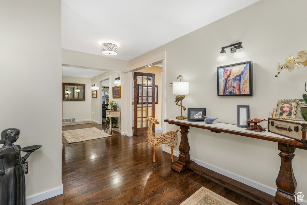 Foyer with baseboards, wood finished floors, and visible vents