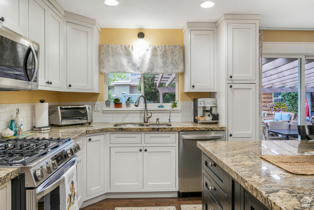 Kitchen featuring a sink, white cabinetry, a toaster, and stainless steel appliances