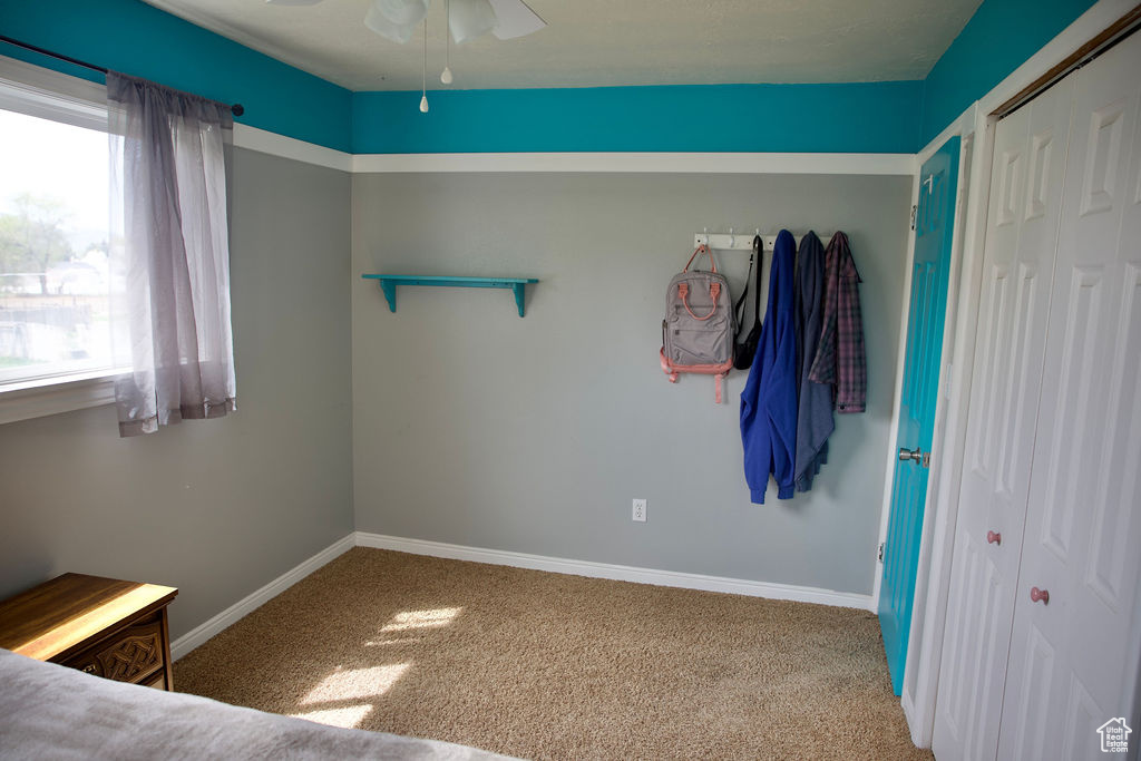 Unfurnished bedroom with baseboards, ceiling fan, and carpet