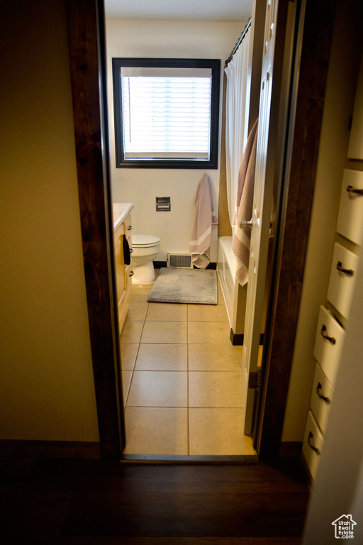 Full bath with toilet, baseboards, tile patterned flooring, and vanity