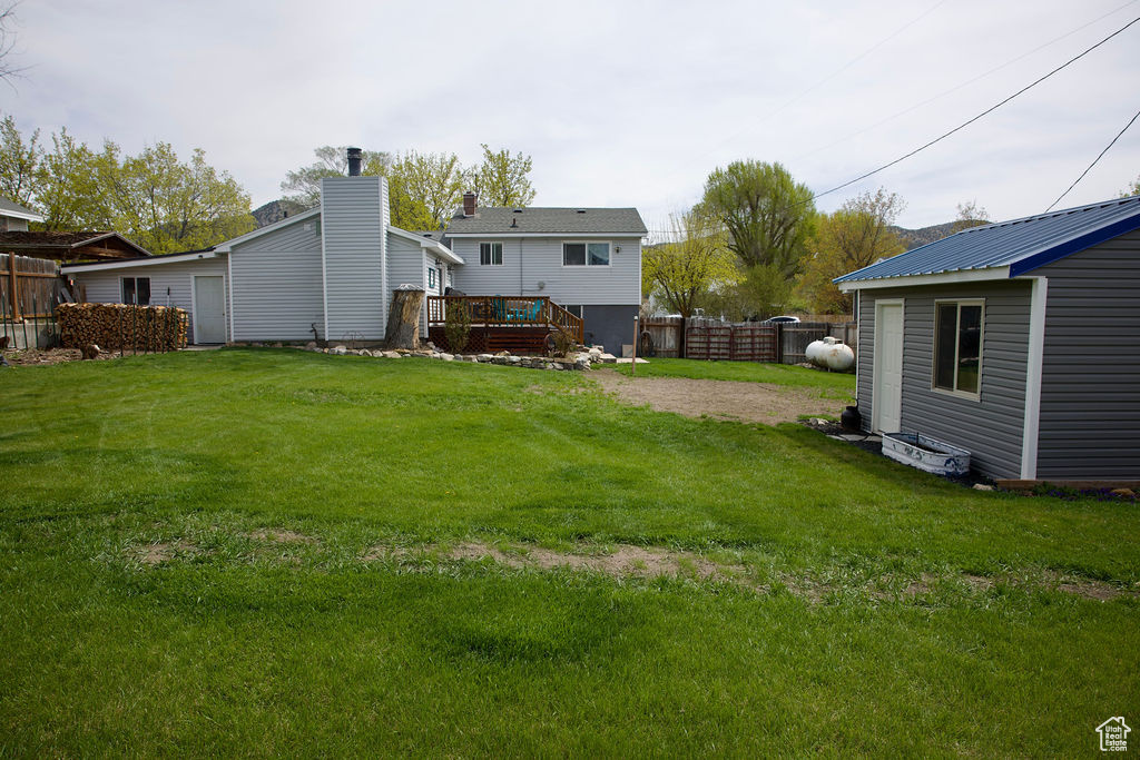 View of yard featuring a fenced backyard, an outdoor structure, and a deck