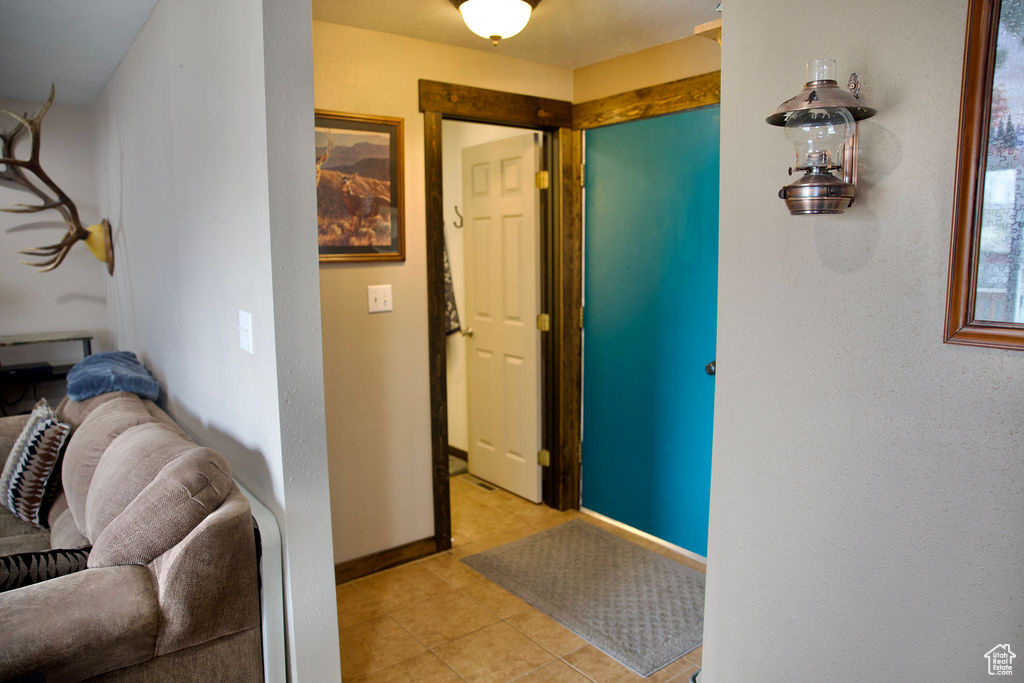 Corridor featuring baseboards and light tile patterned floors