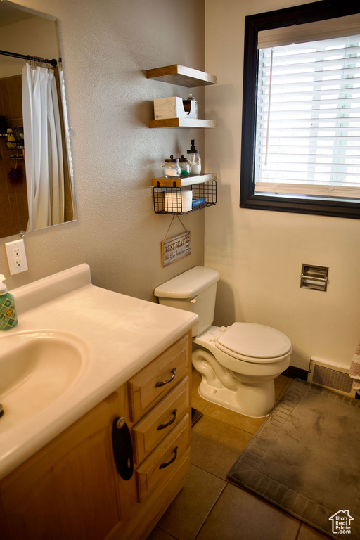 Full bathroom featuring visible vents, tile patterned flooring, curtained shower, vanity, and toilet