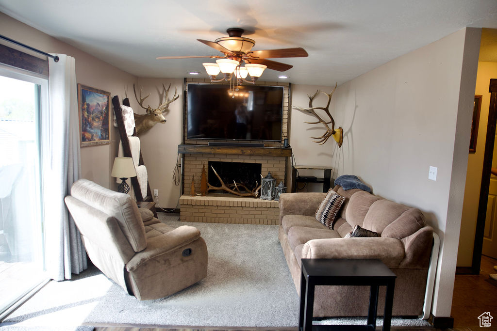 Living area featuring ceiling fan and a fireplace