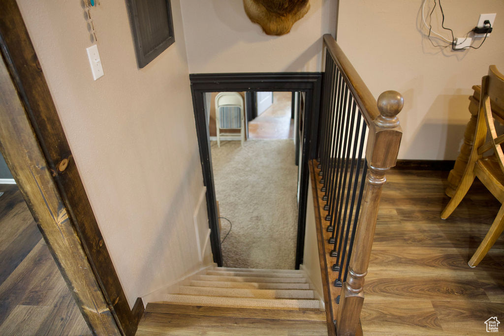 Stairway featuring baseboards and wood finished floors
