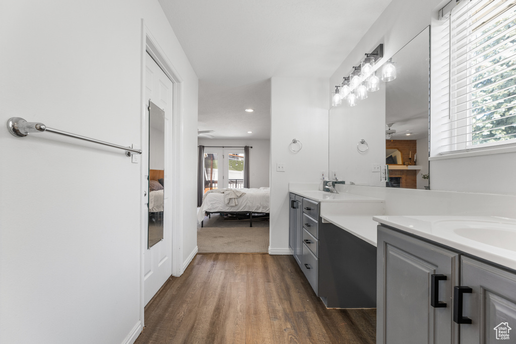 Ensuite bathroom with double vanity, wood finished floors, ensuite bathroom, recessed lighting, and a ceiling fan