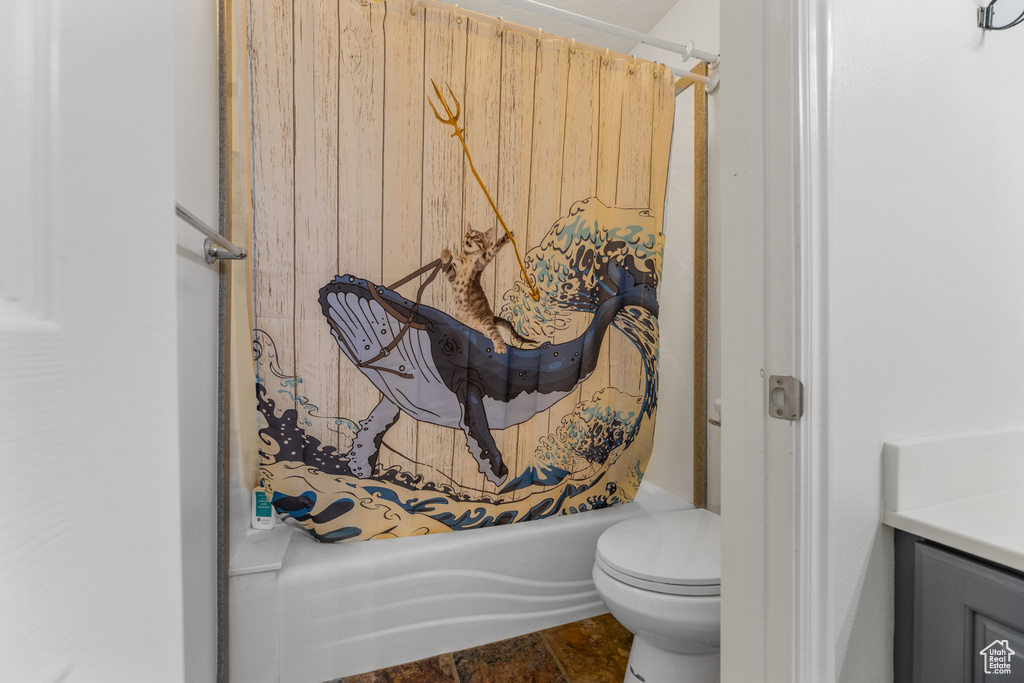 Full bathroom with vanity, shower / bath combo with shower curtain, and toilet