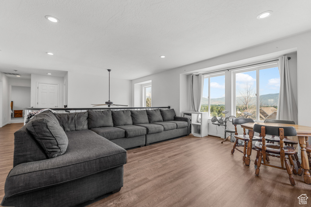 Living room with recessed lighting, a ceiling fan, and wood finished floors