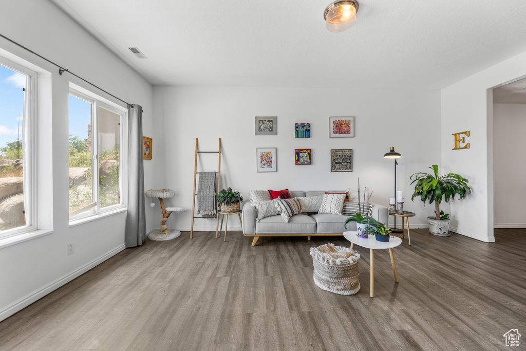 Living area featuring visible vents, baseboards, and wood finished floors