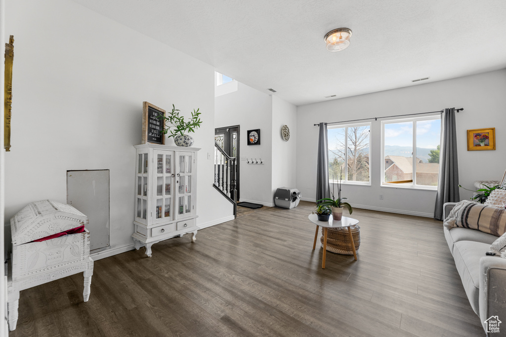 Living area featuring baseboards, wood finished floors, and stairway
