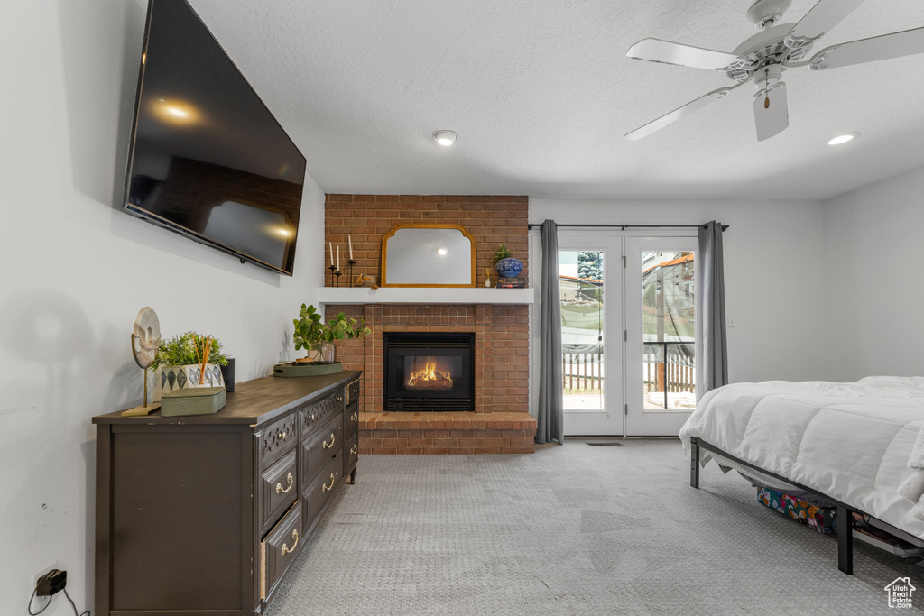 Bedroom with ceiling fan, light carpet, a fireplace, access to exterior, and recessed lighting