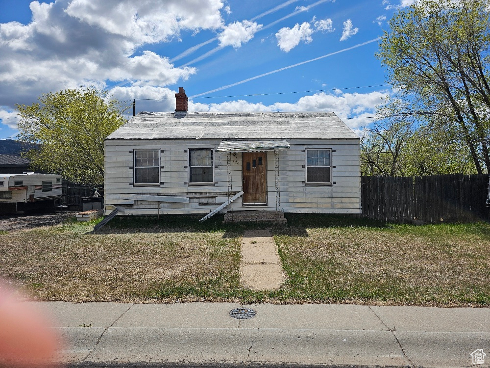 Bungalow-style house featuring fence and a chimney