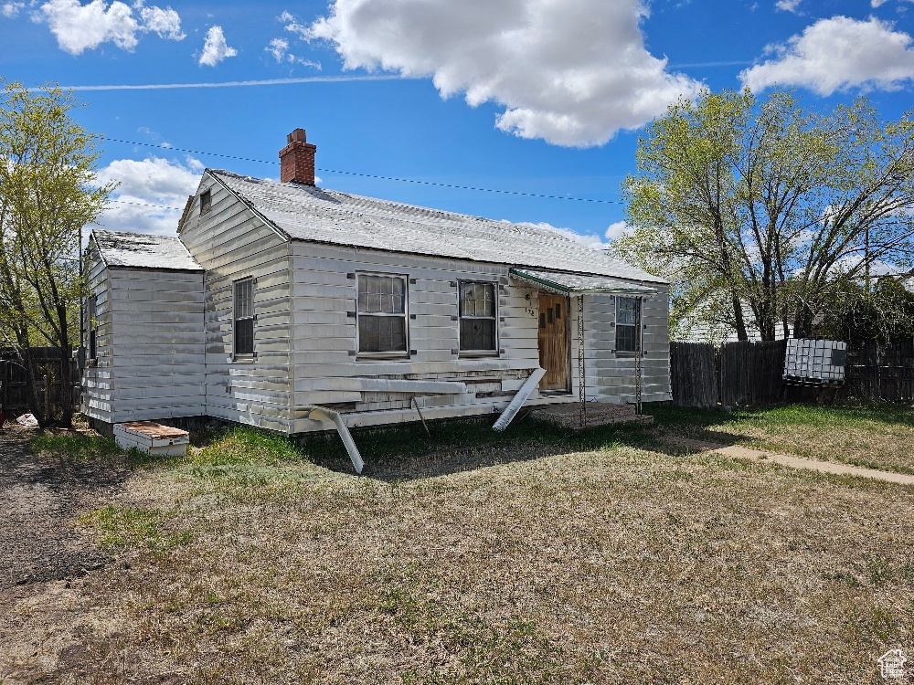 View of front of home with fence and a chimney