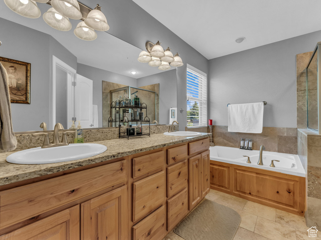 Full bathroom with a sink, double vanity, a shower stall, and a bath