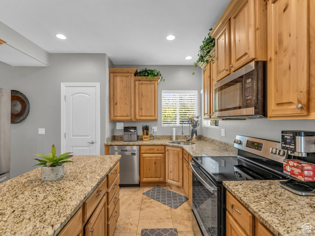 Kitchen featuring light stone countertops, stainless steel appliances, and recessed lighting