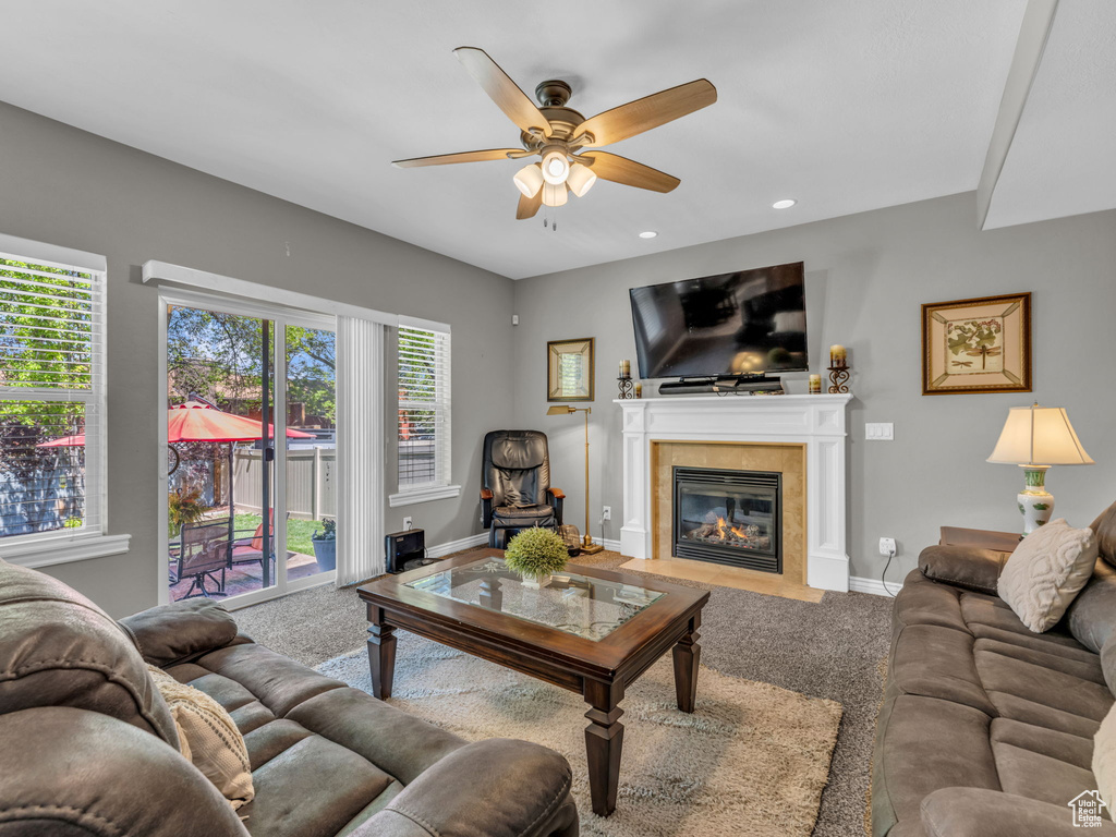 Carpeted living area featuring baseboards, a ceiling fan, recessed lighting, and a tile fireplace
