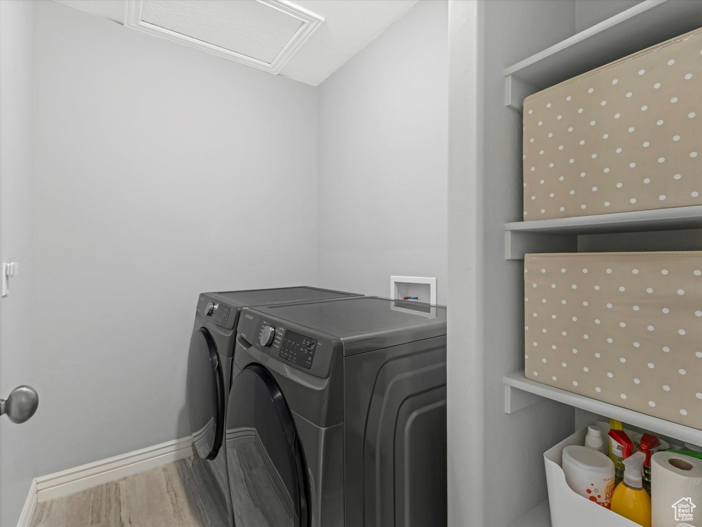 Laundry area featuring baseboards, laundry area, independent washer and dryer, and wood finished floors