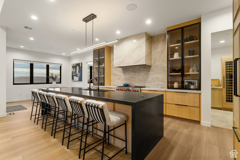 Kitchen featuring a sink, visible vents, light wood-style flooring, a spacious island, and modern cabinets