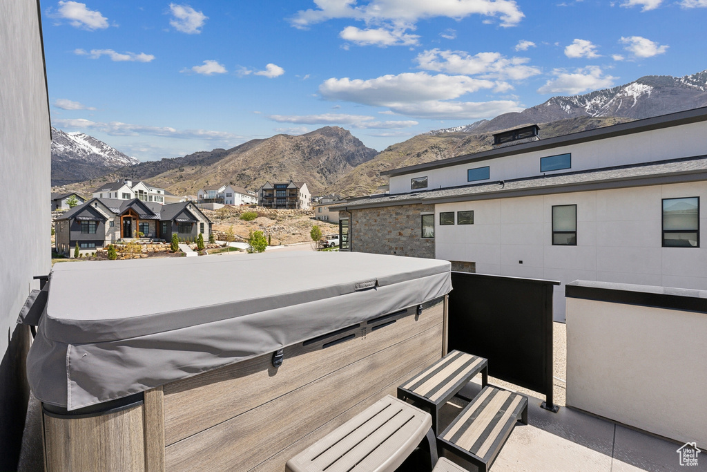 Exterior space featuring a residential view, a mountain view, and a hot tub