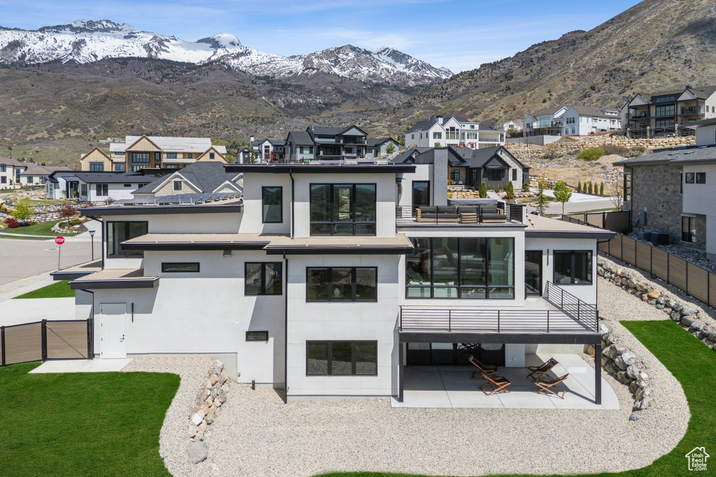 Back of house featuring a residential view, a fenced backyard, a patio area, and stucco siding